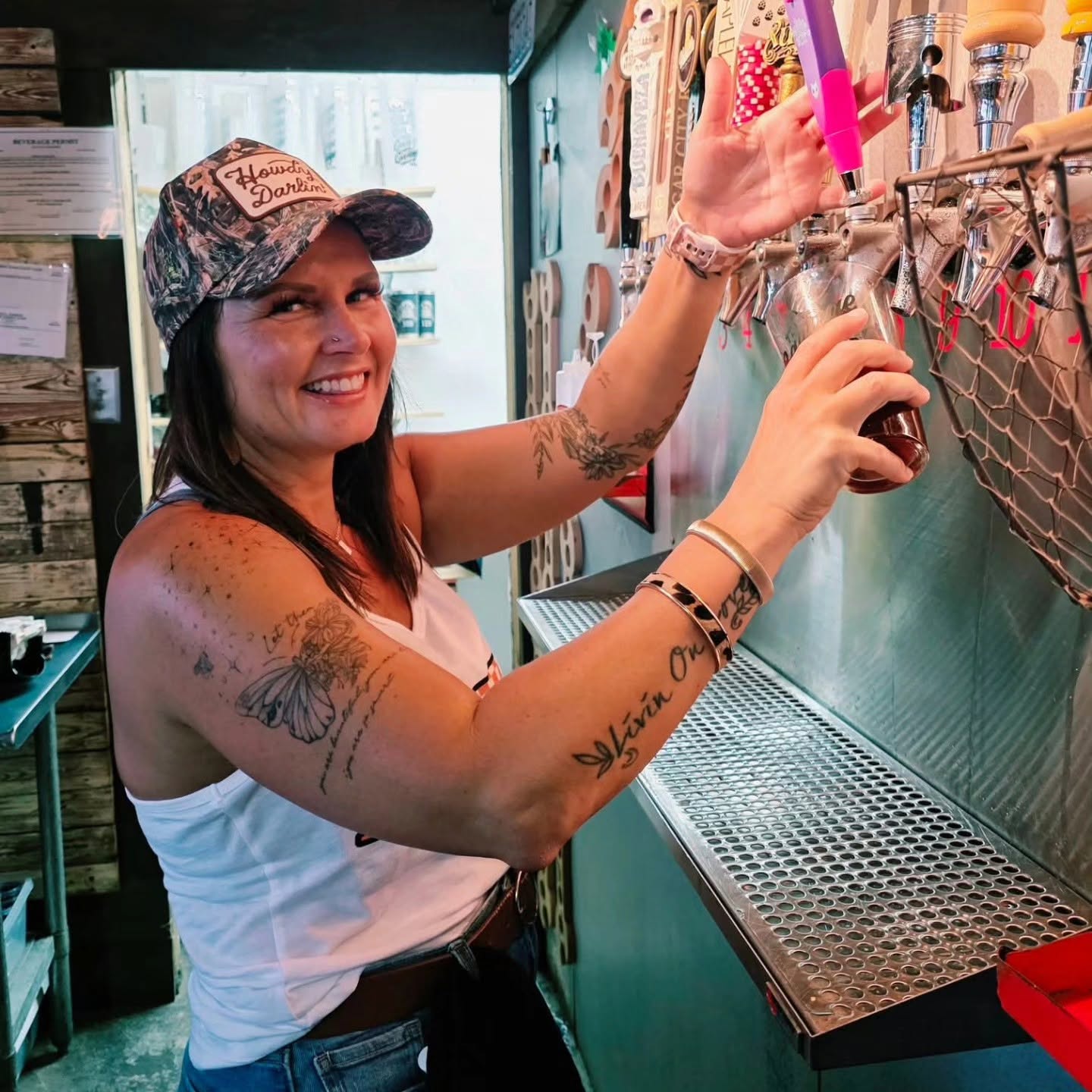 Bartender pouring a draft beer behind the bar at Cofer's Garage