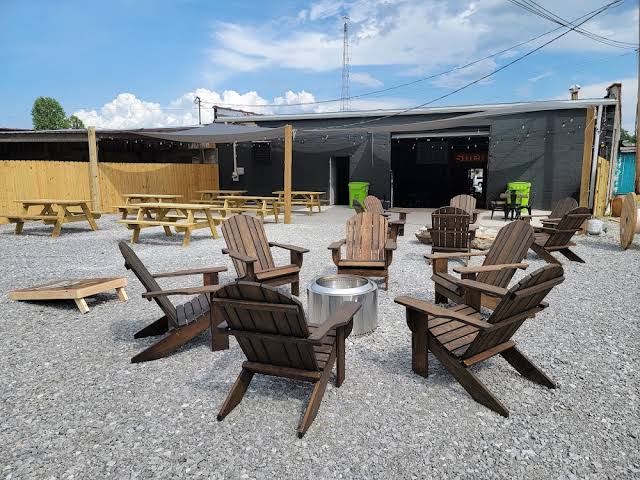 Adirondack chairs and fire pit in the gravel yard at Cofer's Garage