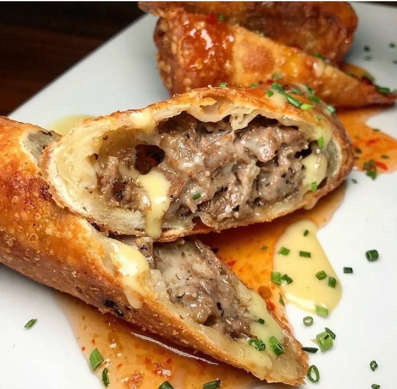 A flaky handheld pastry filled with meat and cheese, served by one of the rotating food trucks